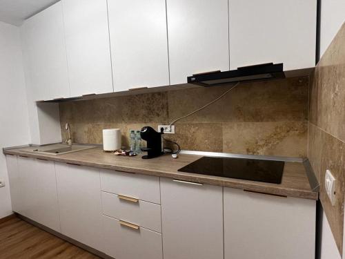 uma cozinha com armários brancos e um lavatório em Florilor Residence I em Piteşti