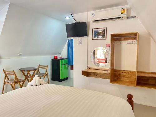 um quarto com uma cama, uma televisão e cadeiras em Pijittra Resort em Uttaradit