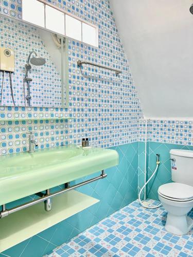 a bathroom with a sink and a toilet at Pijittra Resort in Uttaradit