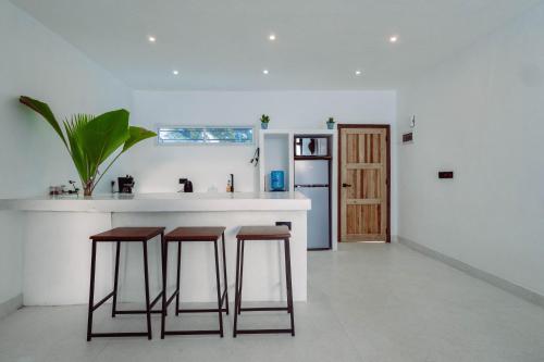 瓦塔姆的住宿－Trio Villas Watamu，厨房配有带凳子的柜台和冰箱。