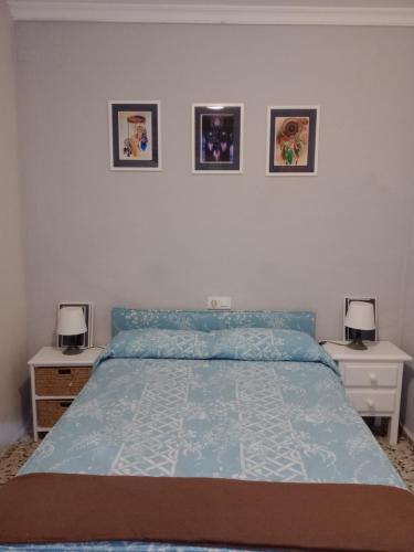 um quarto com uma cama azul com duas mesas de cabeceira e dois candeeiros em Cerca de Sevilla Bosque Suspendido Ideal Familia em Bollullos de la Mitación