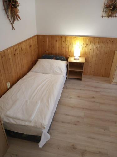 a small bedroom with a bed and a lamp on a table at Apartment Zapart Harrachov in Harrachov