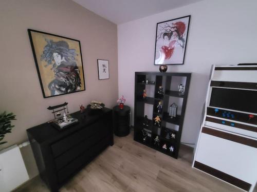 a room with a black dresser and a book shelf at Appartement neuf moderne + parking, Genève in Saint-Genis-Pouilly