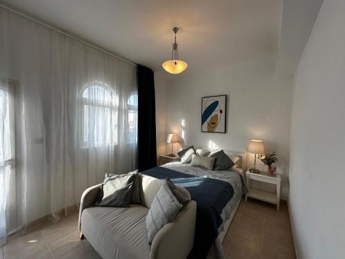 1 dormitorio con 1 cama y 1 sofá en Peaceful home near beach & car, en Dubái