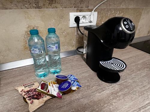 - une cafetière et une bouteille d'eau sur un comptoir dans l'établissement Florilor Residence I, à Piteşti
