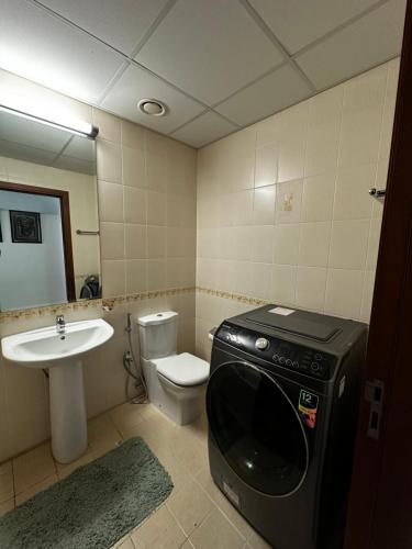 a bathroom with a washing machine and a toilet at Peaceful home near beach & car in Dubai