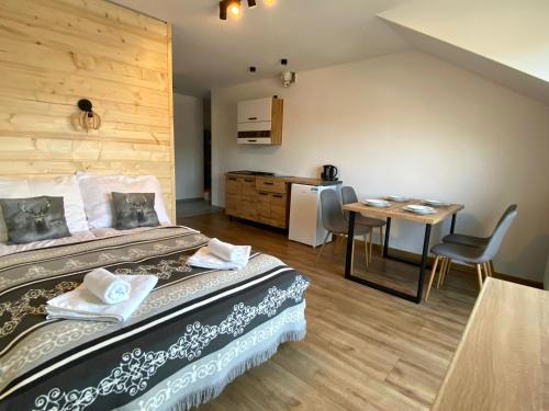 a room with a bed and a table and a kitchen at Willa Widokowa in Wisła