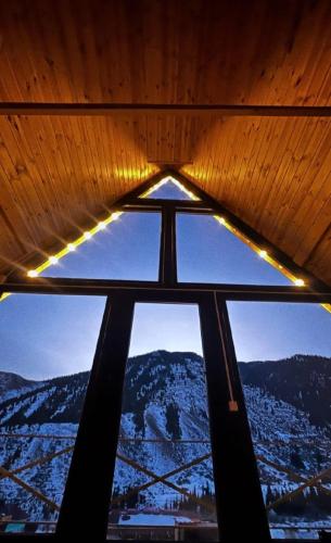 ein Fenster mit Blick auf einen verschneiten Berg in der Unterkunft Kolsay_village in Kurmenty
