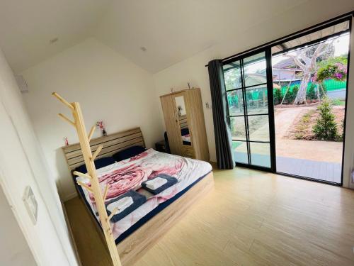 a bedroom with a bed and a large sliding glass door at Piyaporn Guesthouse in Khon Kaen