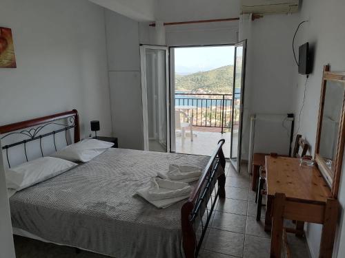 a bedroom with a bed and a view of a balcony at Calypso Apartments in Vathi, Ithaka