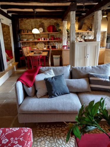 Les Bernardies في Simeyrols: غرفة معيشة مع أريكة عليها وسائد