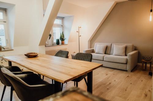 德勒斯登的住宿－Bestlage im Hechtviertel & frisch saniert，客厅配有木桌和椅子