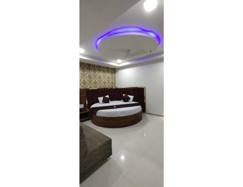a bedroom with a bed and a purple light at Hotel Paradise, Naroda in Ahmedabad