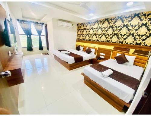 a hotel room with two beds and a large window at Hotel Paradise, Naroda in Ahmedabad