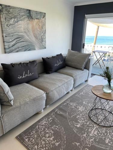 a living room with a couch and a table at TAKE TWO lovely beach apartment, Great Brak River in Groot Brak Rivier