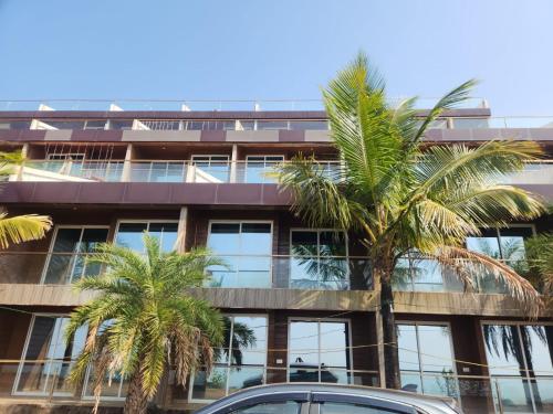 an office building with palm trees in front of it at Seascape Villa in Ānjarle