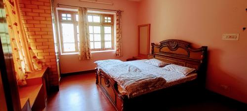 Schlafzimmer mit einem Bett und einem Fenster in der Unterkunft Akash Homestay in Shimla