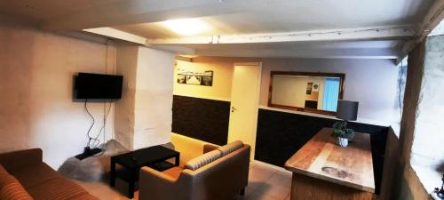 een woonkamer met een bank en een tafel bij Cheap and very central basement apartment - Vindegade 53F in Odense