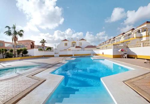 a swimming pool in a resort with blue water at Casa MACON RED in Caleta De Fuste