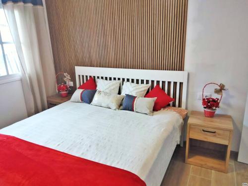 a bedroom with a bed with red and white pillows at Casa MACON RED in Caleta De Fuste