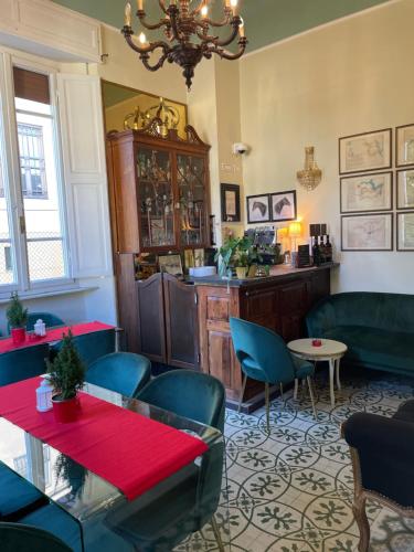 a restaurant with green chairs and tables and a chandelier at Villa Tower Inn in Pisa