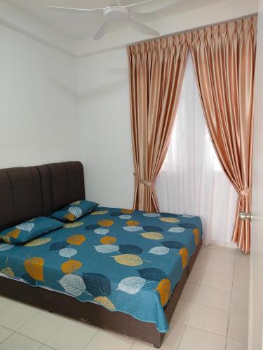 un letto con piumone blu in una camera da letto di Homestay Hufidya a Putrajaya