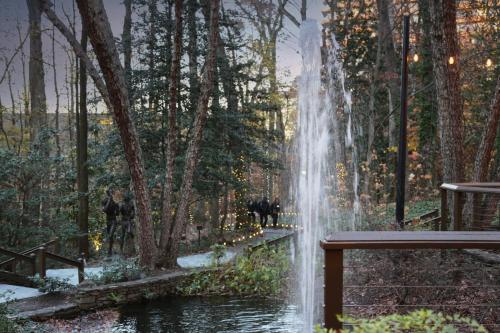a waterfall in a park with people standing near a bench at Crowne Plaza Atlanta Perimeter at Ravinia by IHG in Atlanta