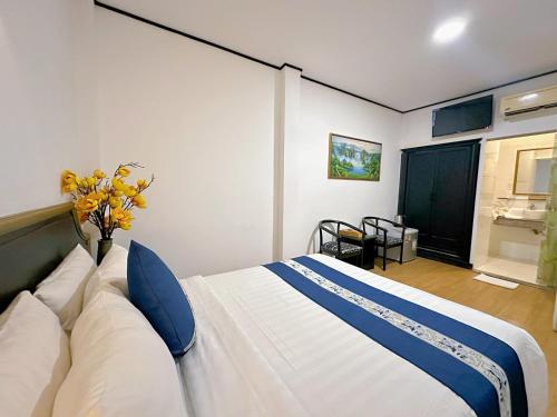 a bedroom with a large white bed with blue pillows at New Star Inn Boutique Hotel-Near Bến Thành Market in Ho Chi Minh City