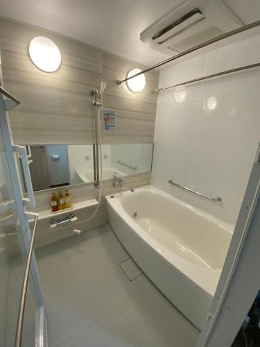a white bathroom with a tub and a sink at MR TOMO FUJI in Fuji