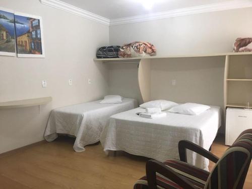 a small room with two beds and a chair at HOTEL CÁ DEI MONTI in Serafina Corêa