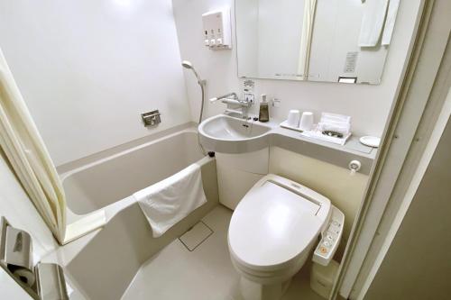 Country Hotel Niigata في نيغاتا: حمام صغير مع مرحاض ومغسلة