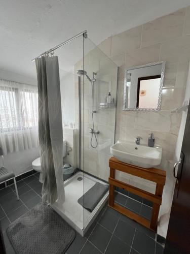 a bathroom with a glass shower and a sink at Casa da Avó Maria, Largo de Santo António, n 97395AL in Freixo de Espada à Cinta