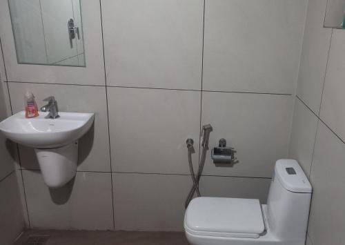a bathroom with a sink and a toilet and a mirror at Niks homestay B in Trichūr