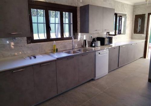 a kitchen with white cabinets and a sink at oeiras Lagoas Parque ,elite home in Porto Salvo
