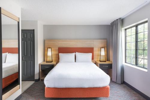 a hotel room with a bed and two windows at Candlewood Suites Eagan - Mall of America Area by IHG in Eagan