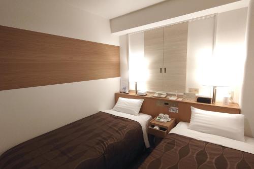 Habitación de hotel con 2 camas y ventana en Country Hotel Niigata en Niigata