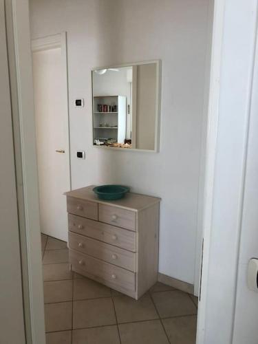 a bathroom with a dresser and a mirror on the wall at Casa Marina - MONEGLIA APARTMENTS in Moneglia