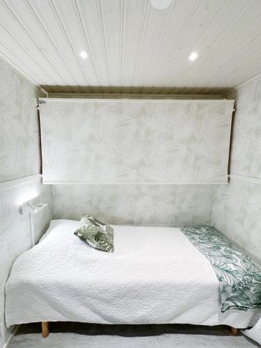 a bedroom with a white bed with a headboard at Ystad Holiday Houses in Ystad