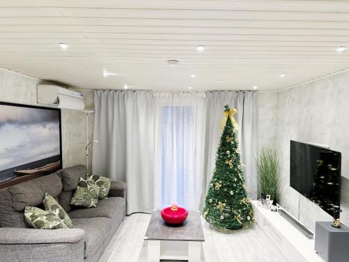 a living room with a christmas tree and a couch at Ystad Holiday Houses in Ystad