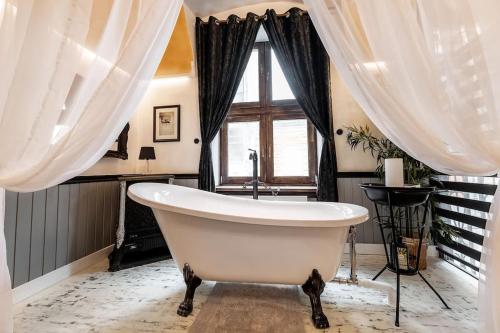 a bath tub in a bathroom with a window at Friday’s apartman in Debrecen