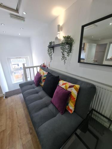 - un canapé gris avec des oreillers dans le salon dans l'établissement Smart & Bright Apartment, à Londres