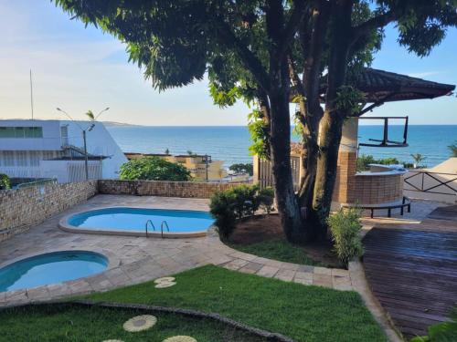 a backyard with a swimming pool and a tree at Cobertura exclusiva em ponta negra com vista para o mar in Natal
