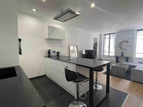 une cuisine avec une table noire et un salon dans l'établissement Appartement haut de gamme, à Saint-Germain-en-Laye