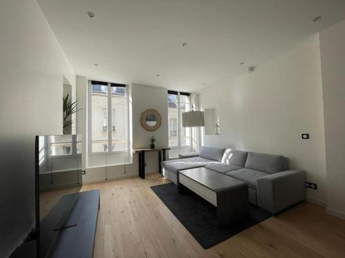 a living room with a couch and a table at Appartement haut de gamme in Saint-Germain-en-Laye