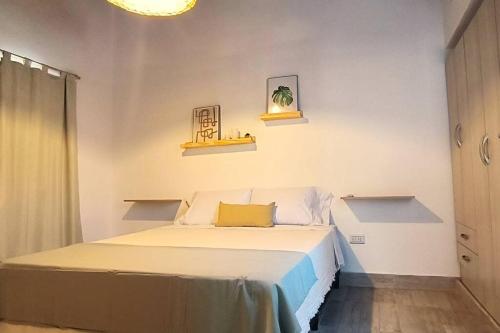 ein Schlafzimmer mit einem Bett mit zwei Regalen an der Wand in der Unterkunft Casa de los Cerros - Vaqueros in Vaqueros