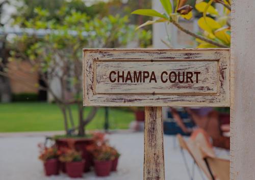 a sign that reads champa court with potted plants at Ajit Bhawan - A Palace Resort in Jodhpur
