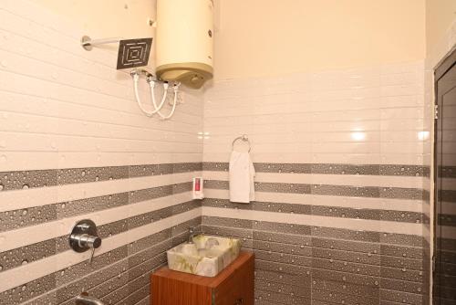 ein Bad mit grauen und weißen Streifen an der Wand in der Unterkunft Himalayan Hill Top Resort in Kanatal
