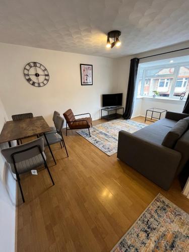 a living room with a couch and a table at St Denys 2 bedroom flat, Convenient location next to station, Great for contractors in Southampton