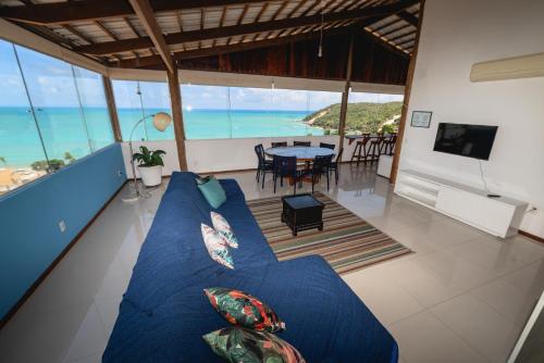 a blue couch in a living room with a view of the ocean at Cobertura exclusiva em ponta negra com vista para o mar in Natal