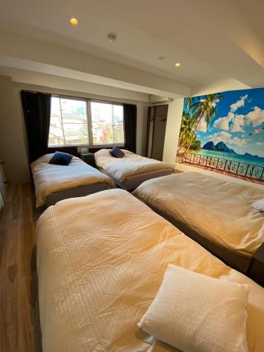 a row of beds in a room with a mural at MR TOMO FUJI in Fuji